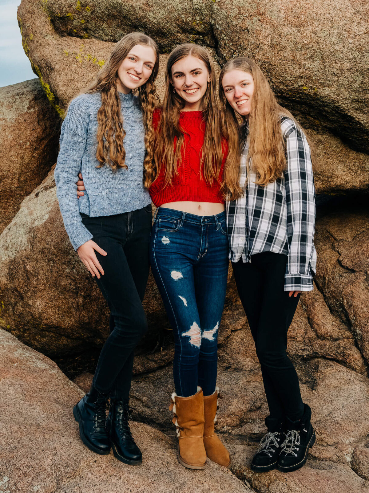 Sisters pose in front of boulder in session with Prescott family photographer Melissa Byrne