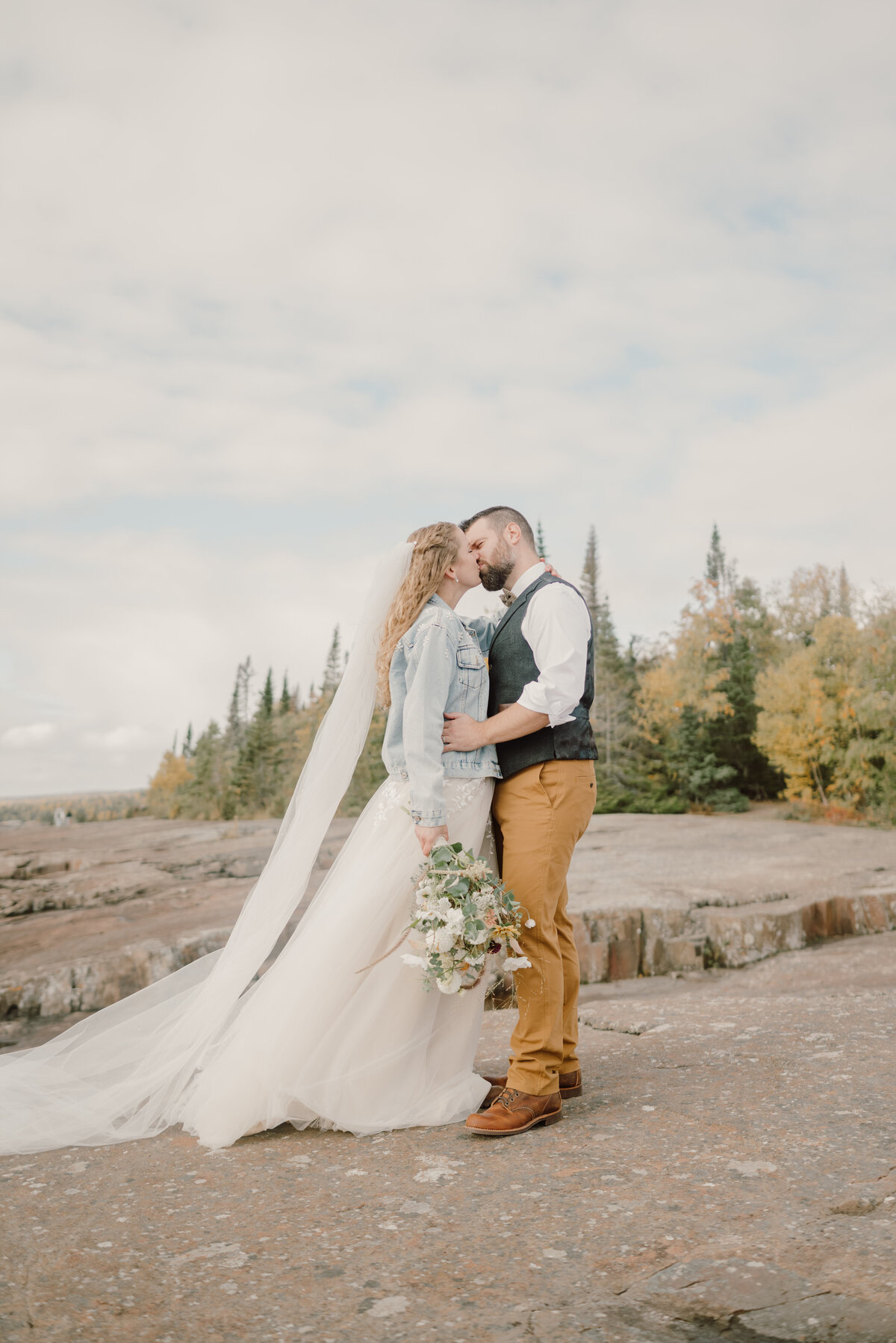 couple kissing on the cliff rocks