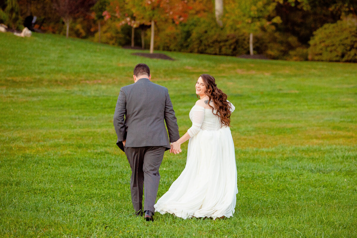 Bride looks over her shoulder as she walks with her husband.