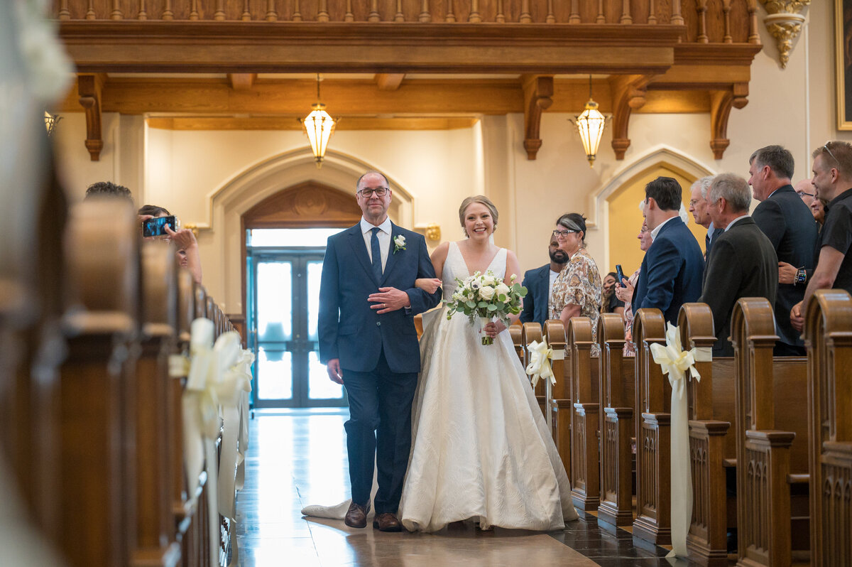 Father walking bride down isle during wedding ceremony at Saint Peters Cathedral in Erie Pennsylvania.