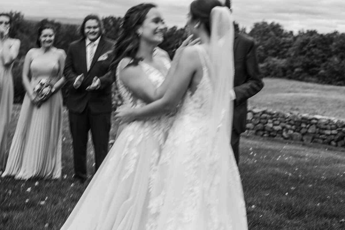 Two brides embrace on their wedding day