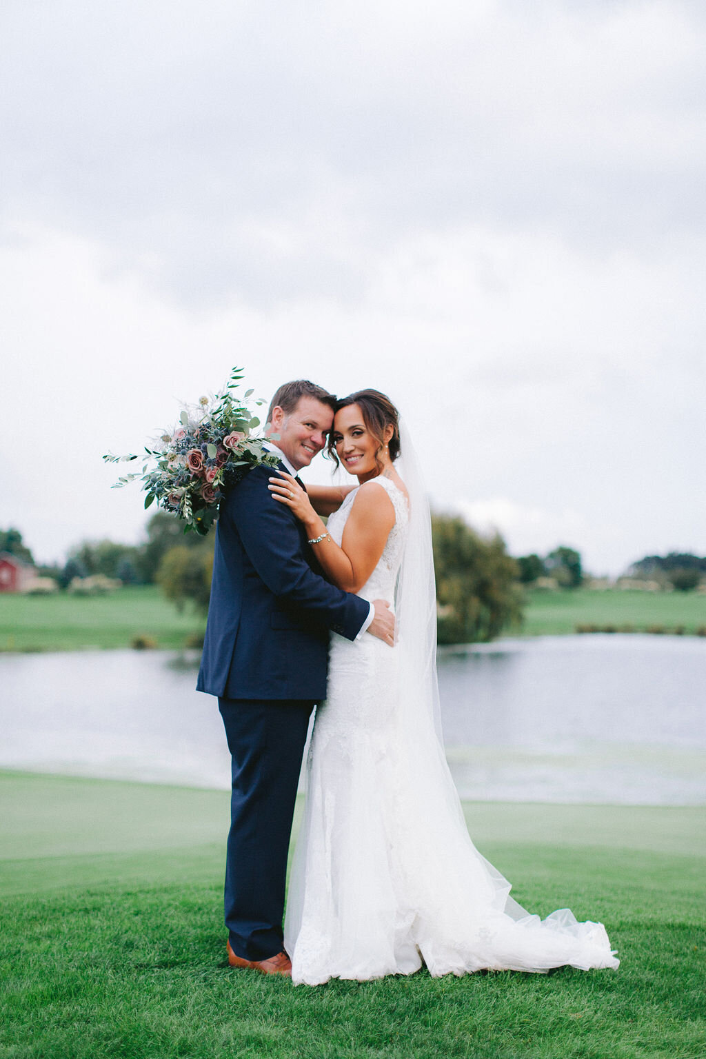 Bride and Groom  posing in front of the pond at Langdon Farms.