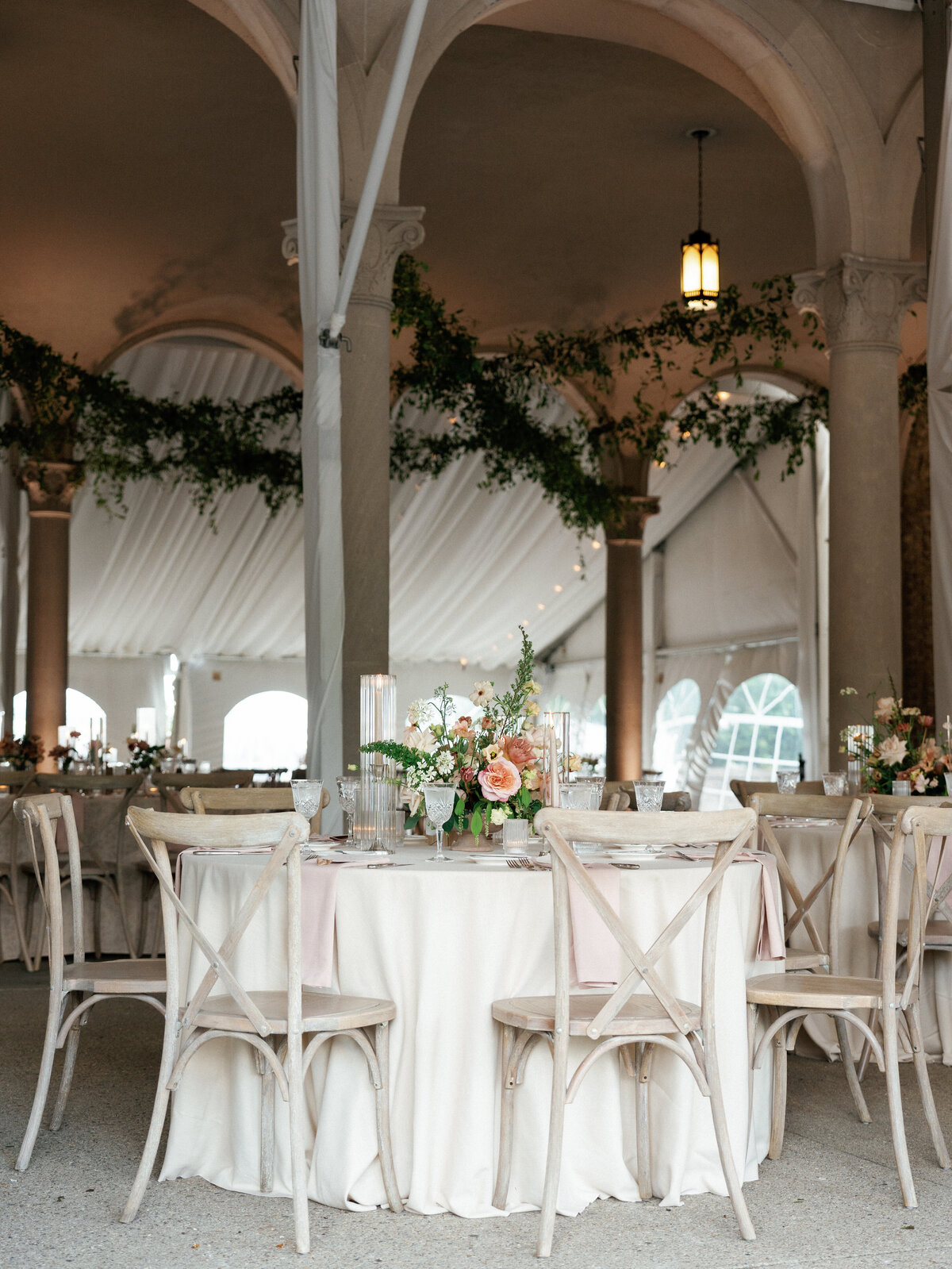Reception table adorned with light linen and garden inspired floral centerpiece.