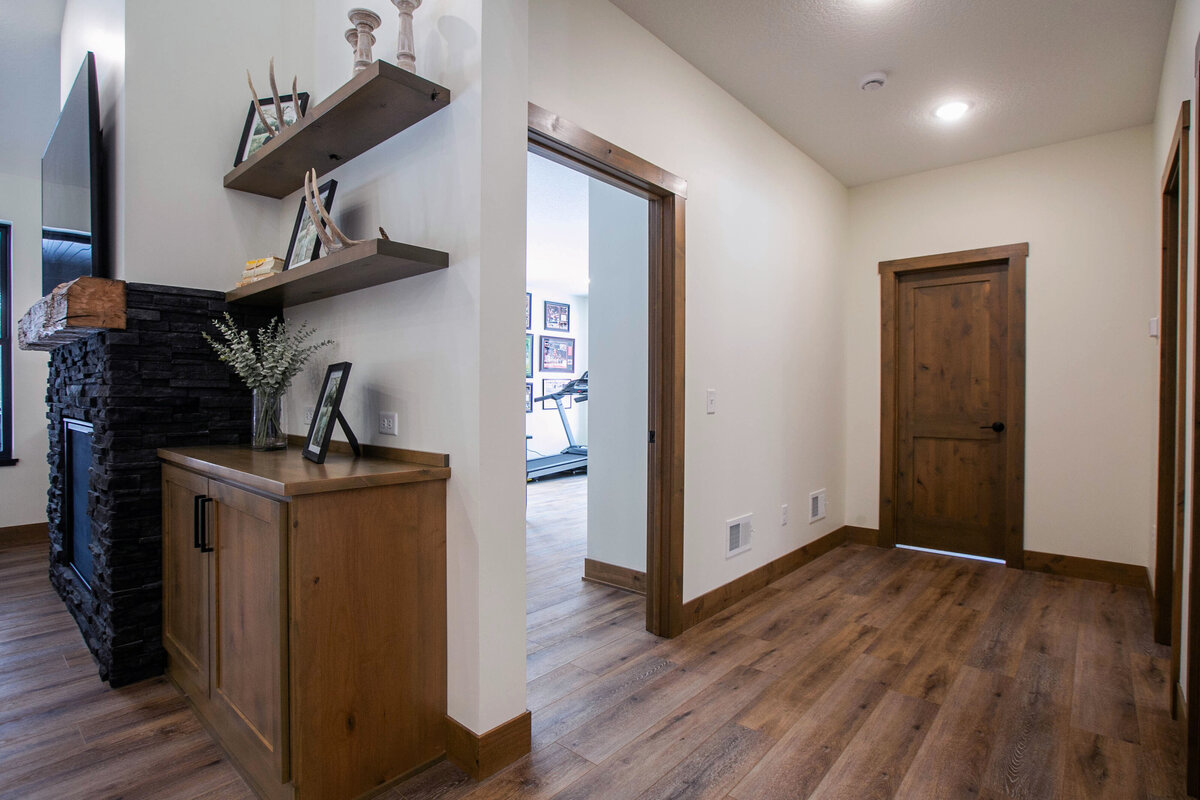 Open Concept Custom Home in Elk River Minnesota hallway to primary bedroom with wood floors and neutral tones by Cornersetone Custom Builds
