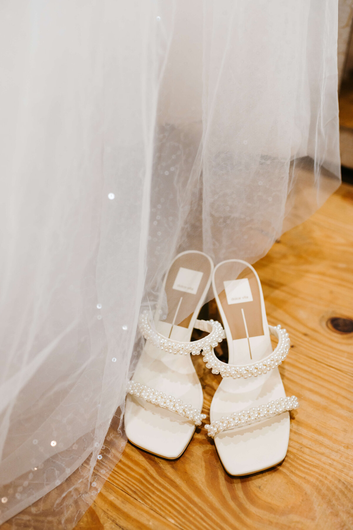 Charlottesville wedding photographer captures white sandal heels sitting next to a tulle and sparkle skirt