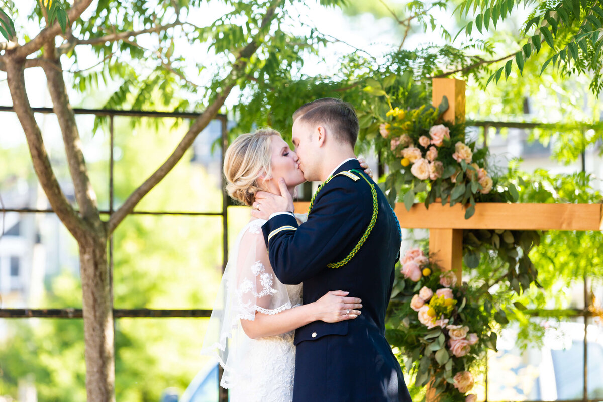 Bride and groom first kiss at wedding ceremony at Fat Bottom Brewery in Nashville, TN