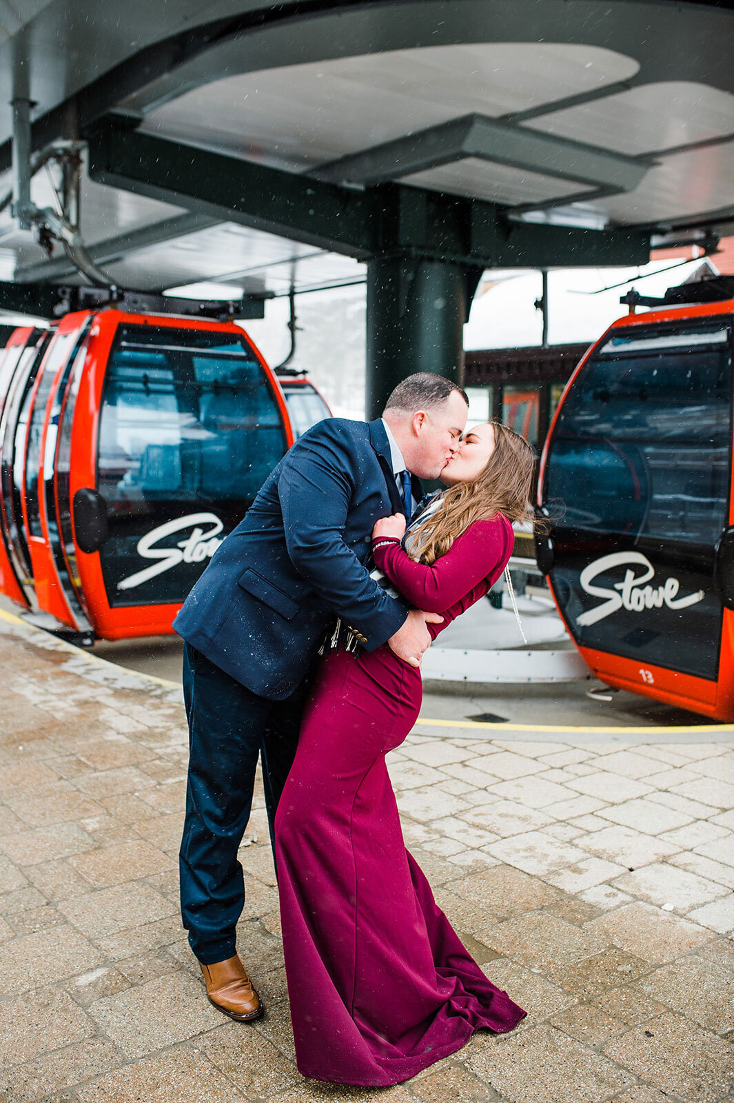 couple kissing in front of gondola at stowe mountain resort spruce peak lodge elopement