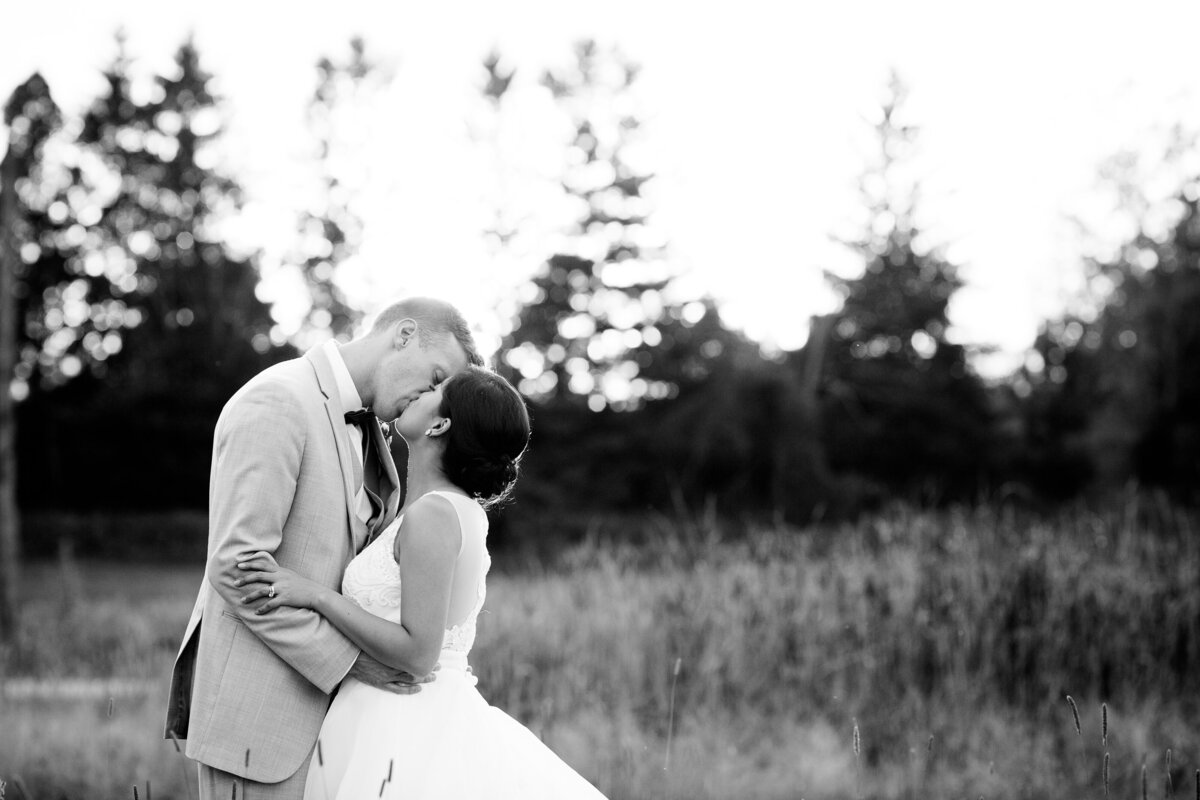 Couple embracing in a field at sunset at The Clearing Shedden