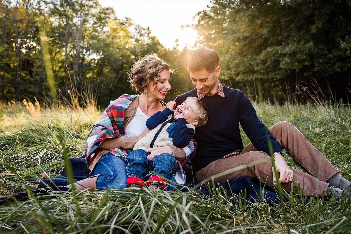 Family laughing in field goldenhour