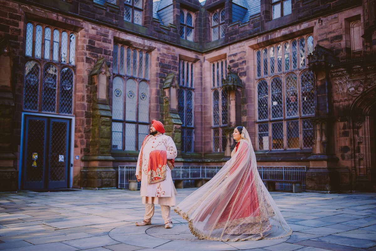 Sikh bride and groom looking away from the camera and twirling at the princeton university nj