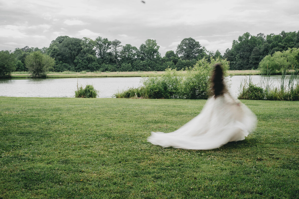 bride walking next to a lake