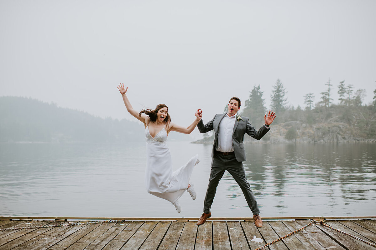 Couple jumping like they've just won the lottery during their portrait session at their small wedding in Pender Harbor B.C