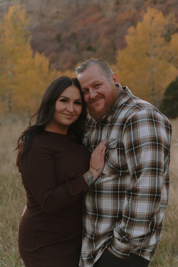 A husband and wife smile at the camera for a couples portrait that will capture their memories and love forever.