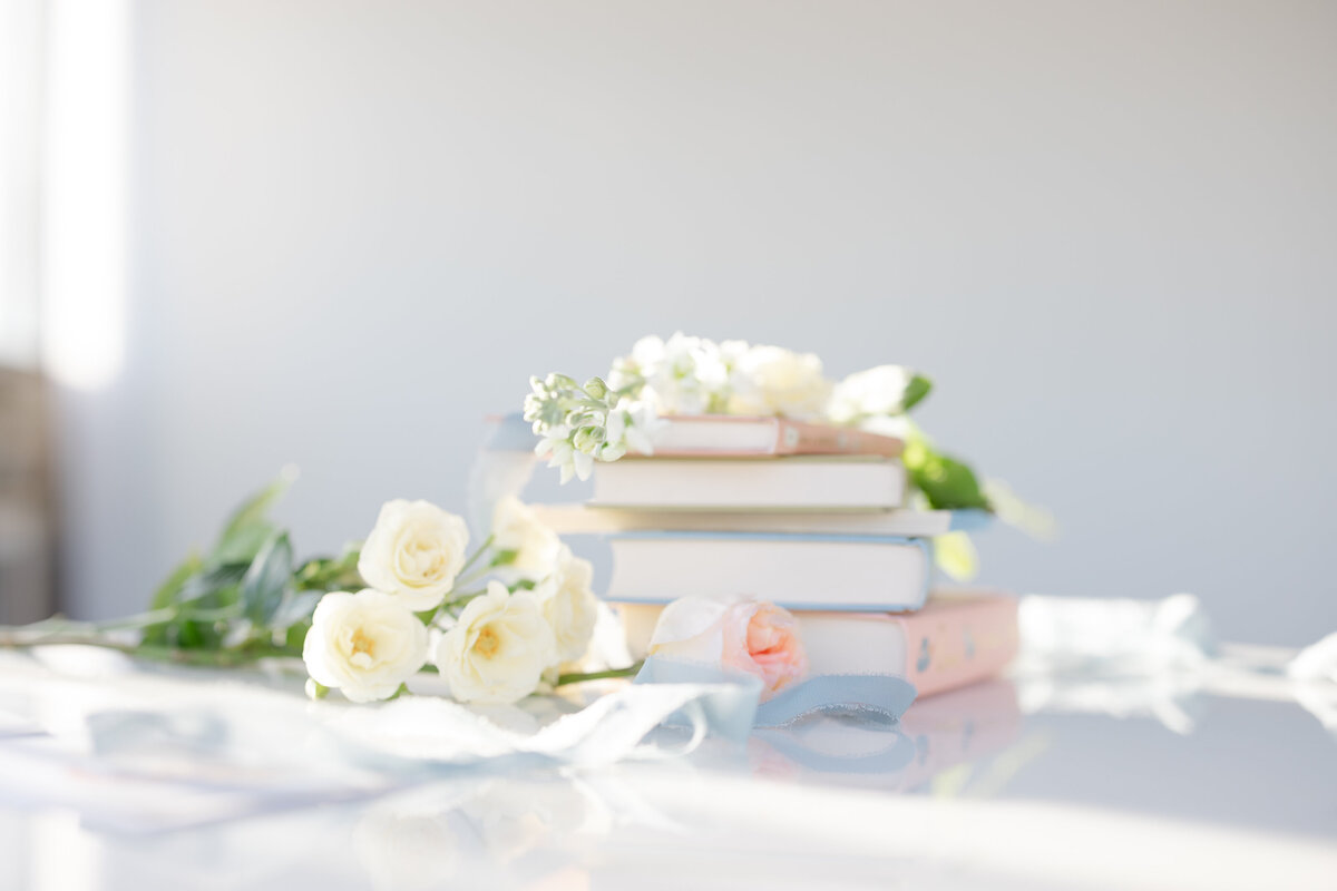 light, airy, and soft lighting shows books and flowers delicately placed on a table