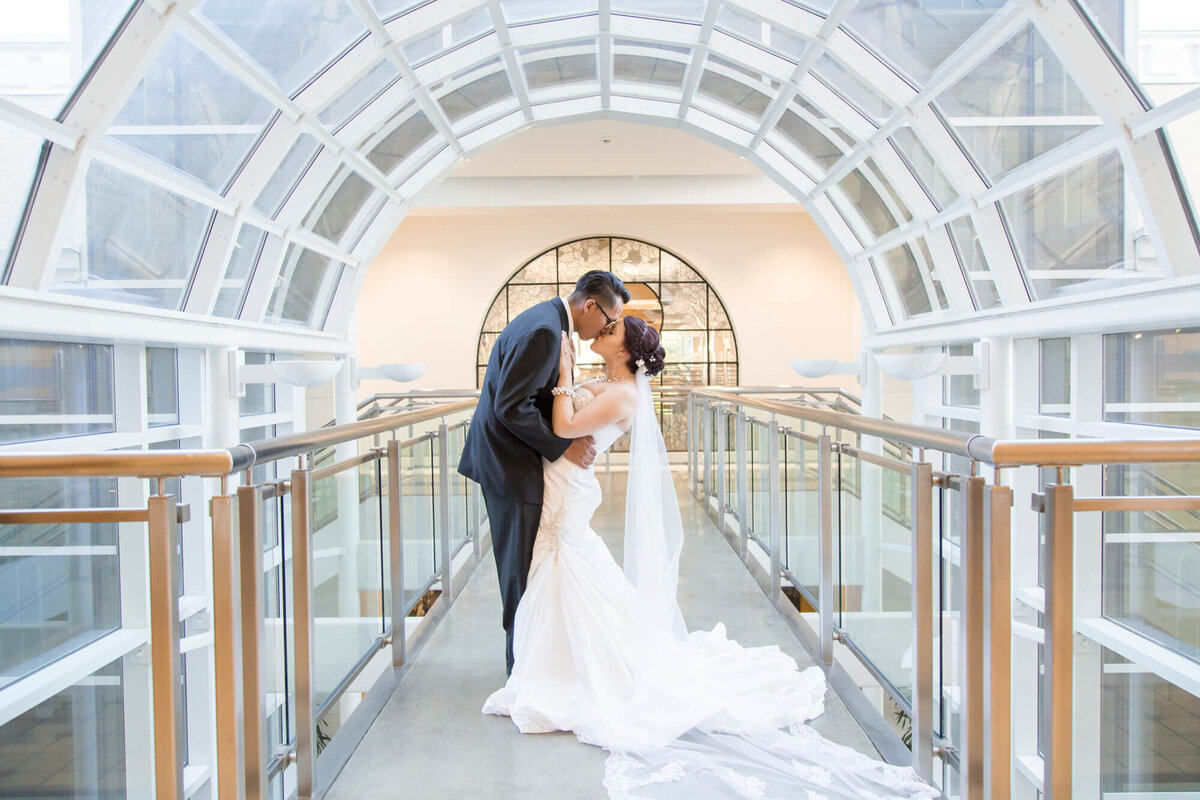 a wedding couple inside on a bridge surrounded by beautifully lit windows