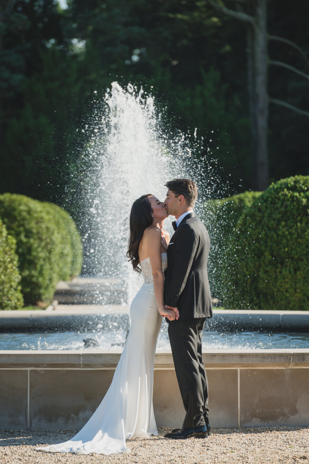 bride and groom kissing by the fountain at Oheka Castle