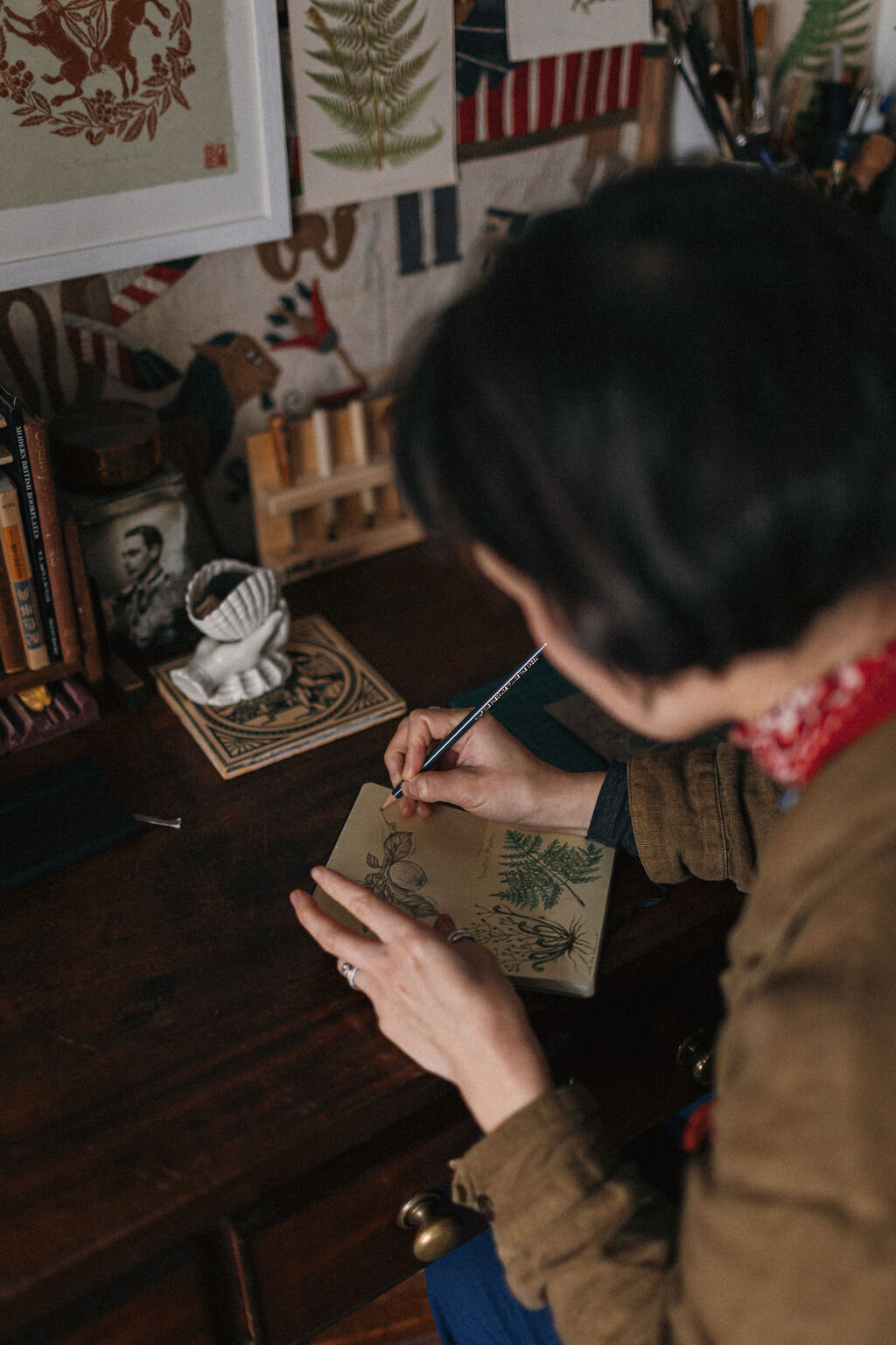 Artist Rachel Snowdon drawing in her sketchbook in her tiny home studio in Devon 