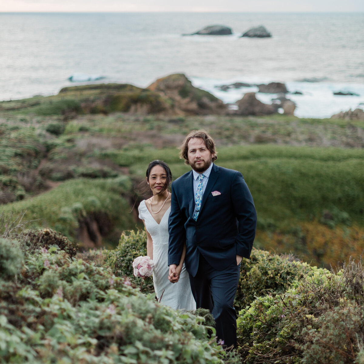 Couple poses on a path along the coast of Highway 1