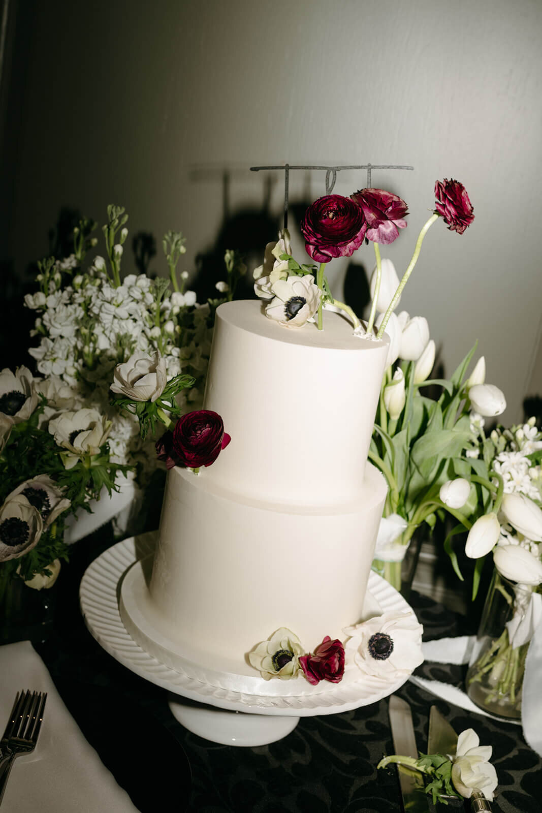 Wedding cake at St. Regis Aspen, decorated with intricate floral details and displayed on a refined stand in a romantic setting.