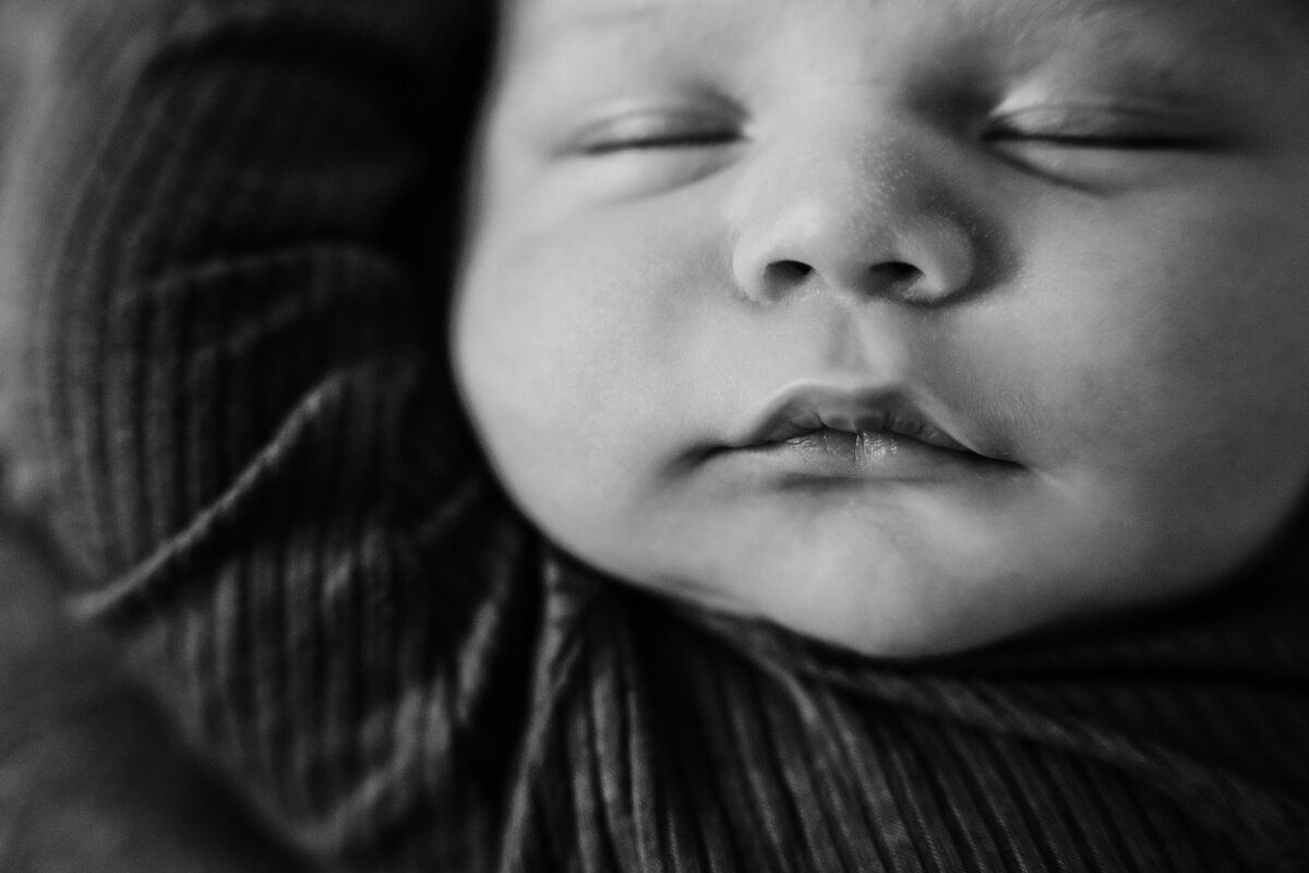 Newborn Photographer, a baby sleeps , a large hood snug around his head