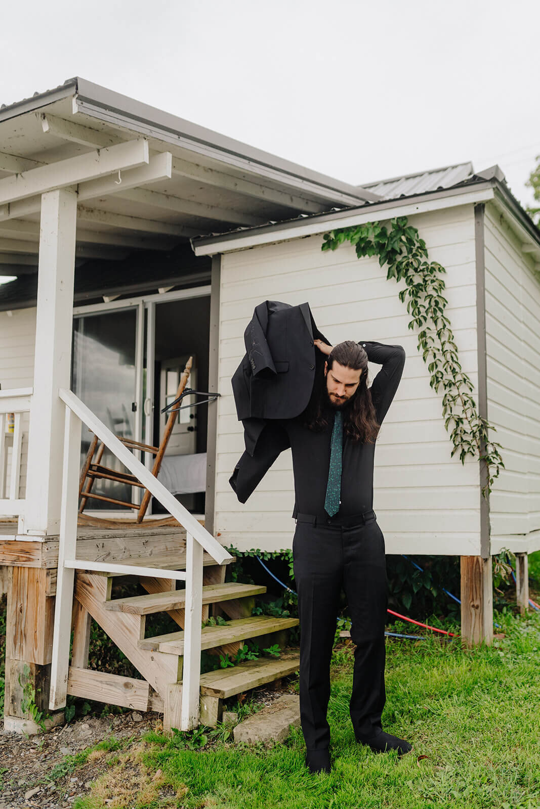 Groom putting suit jacket on atFinger lakes wedding