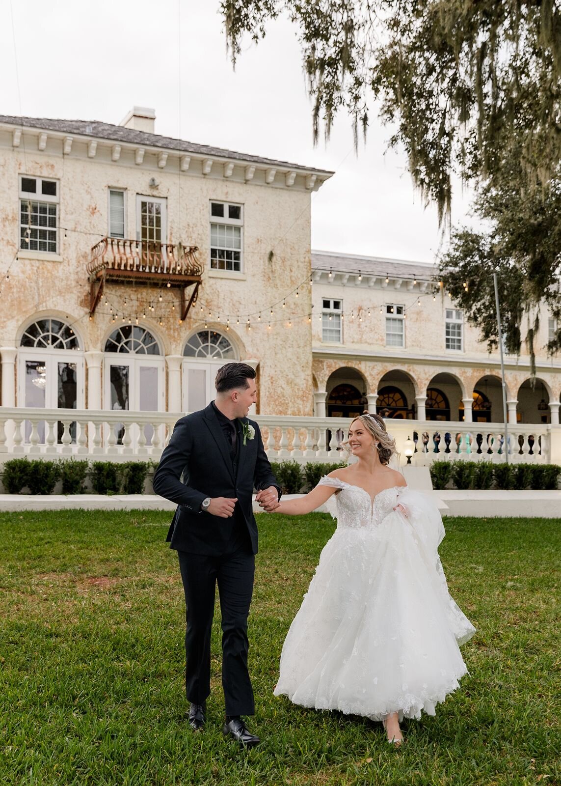 Bride and Groom walking in grass at Bella Cosa, Lake Wales, Florida