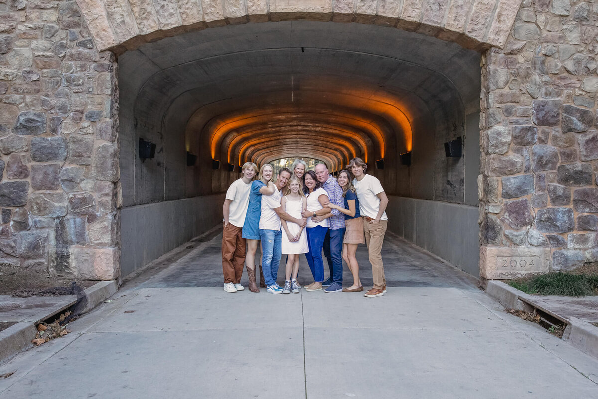 A large family standing under an archway in a brick tunnel looking at the camera at Jeffrey Open Space.