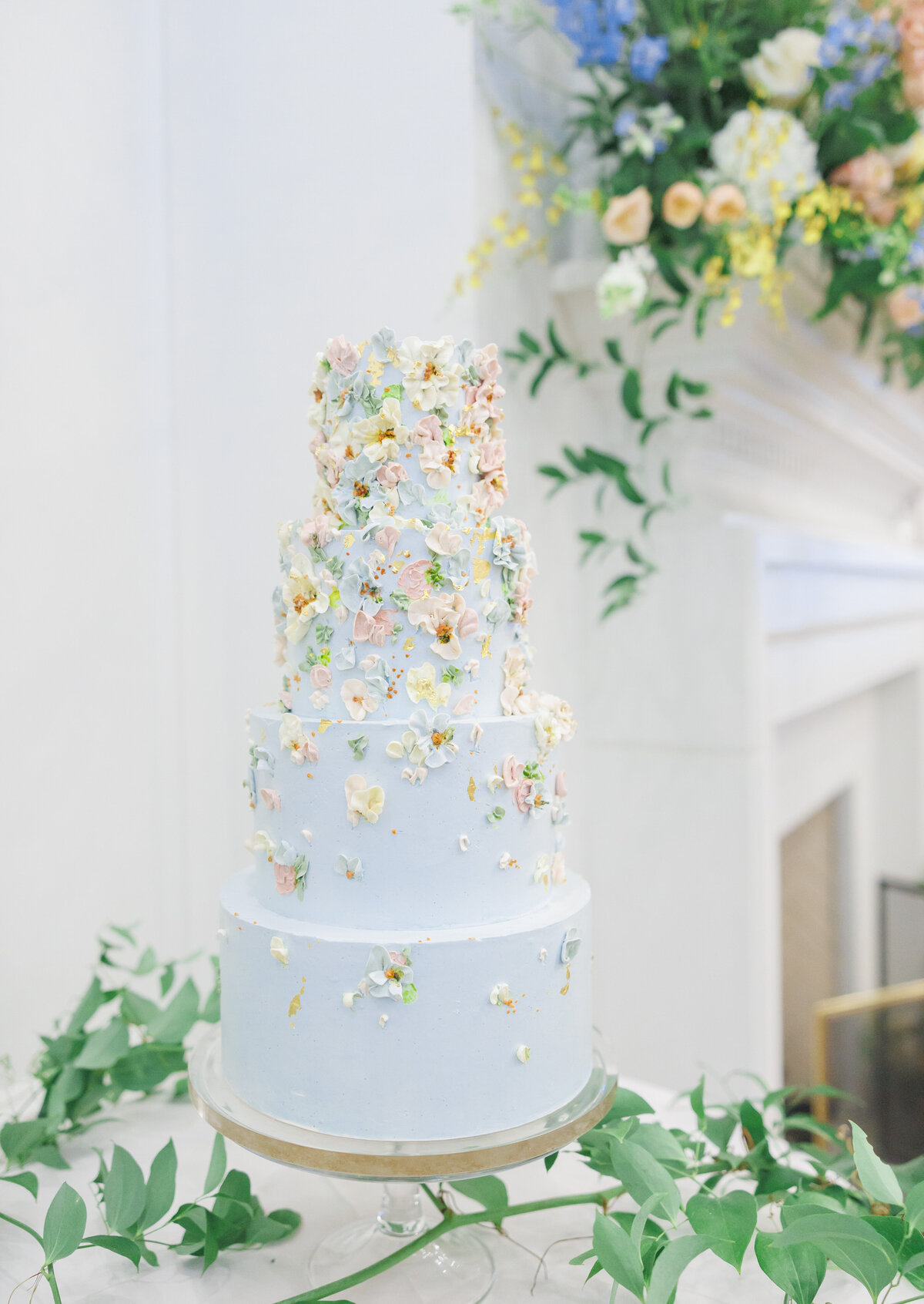 Four tier blue wedding cake with hand piped sugar flowers