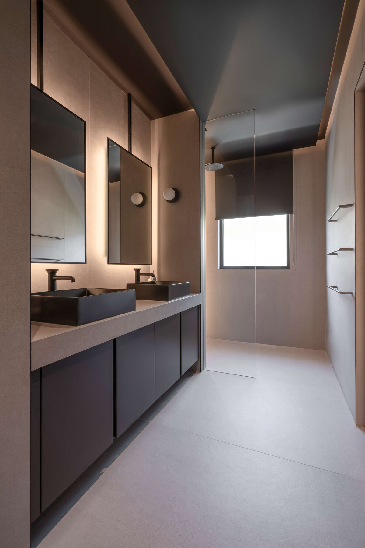 Sleek grey bathroom with dark cabinets, light flooring, and double black sinks.