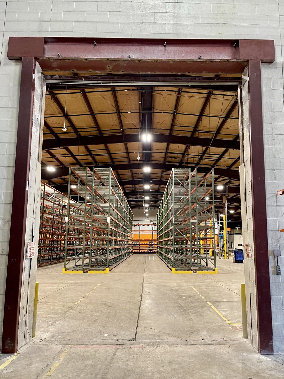 Installed welded steel door frame with reinforced metalwork for industrial building entryway.”