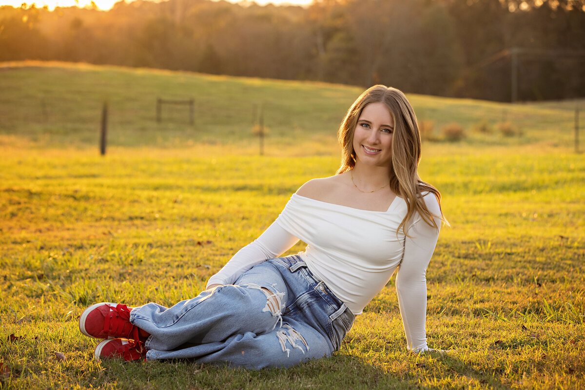High school senior portrait with golden light and fall foliage at Anne Springs Close Greenway in Fort Mill SC at sunset