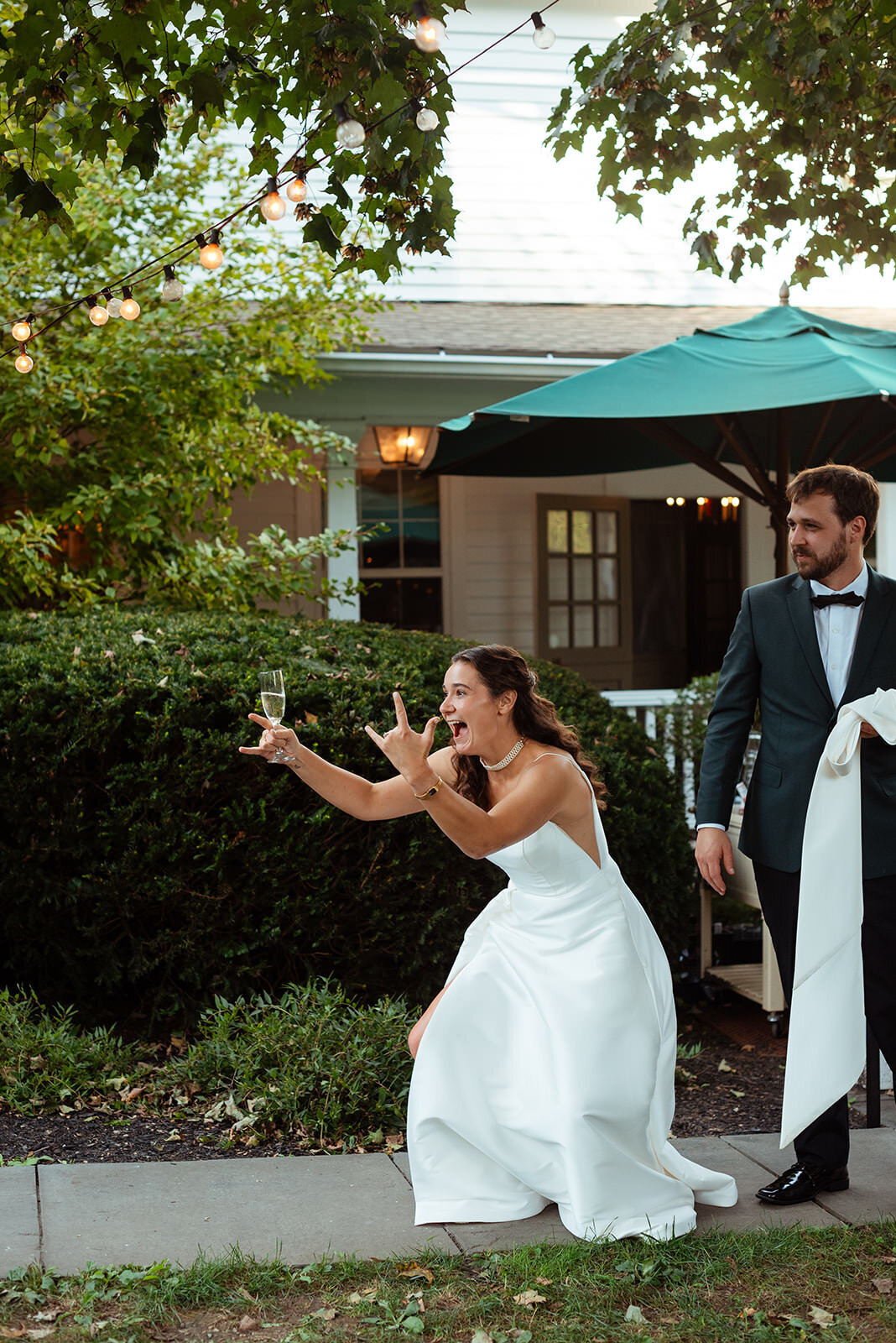 Bride bending over with "I love you" fingers