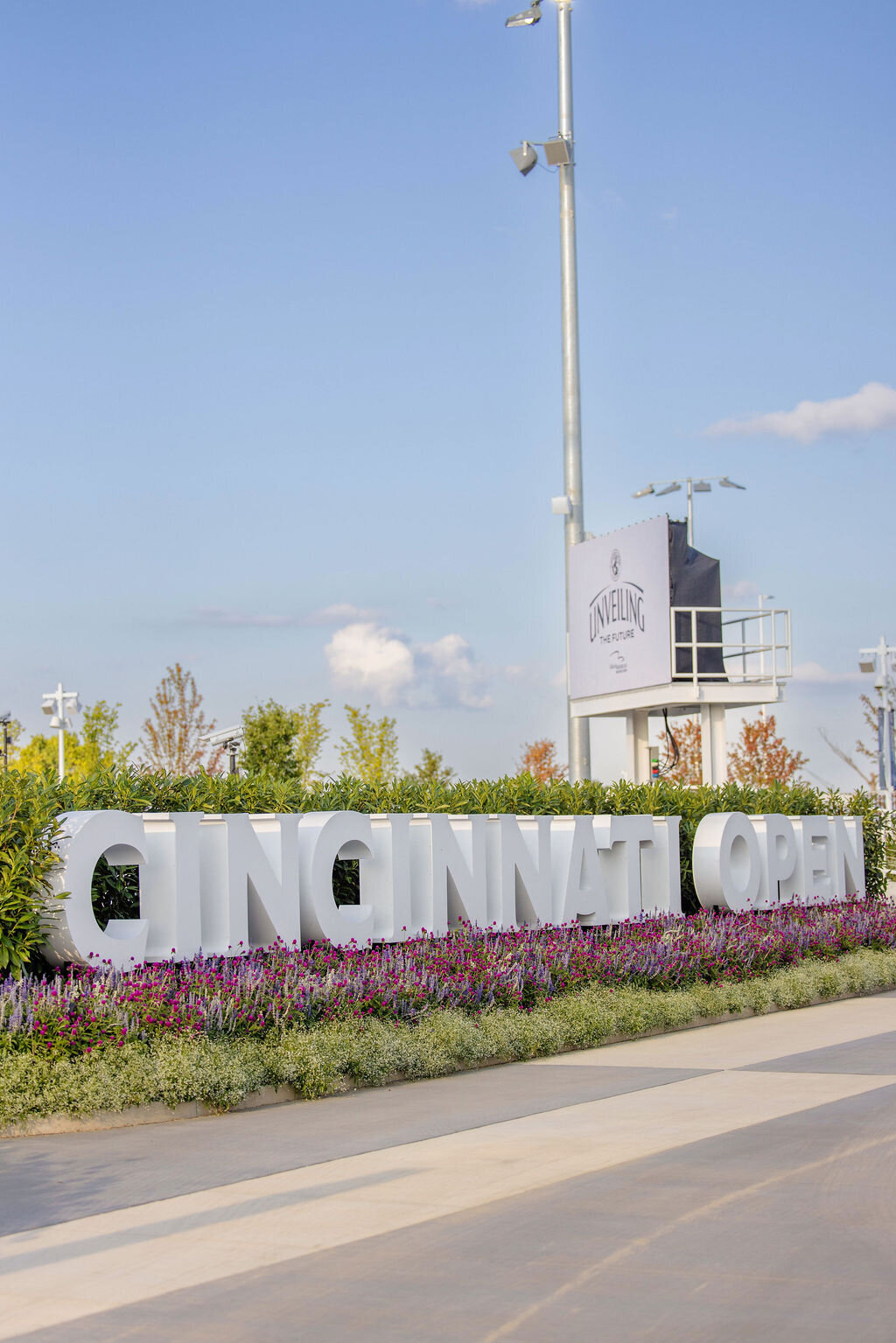 Large outdoor “Cincinnati Open” sign with flowers in front.