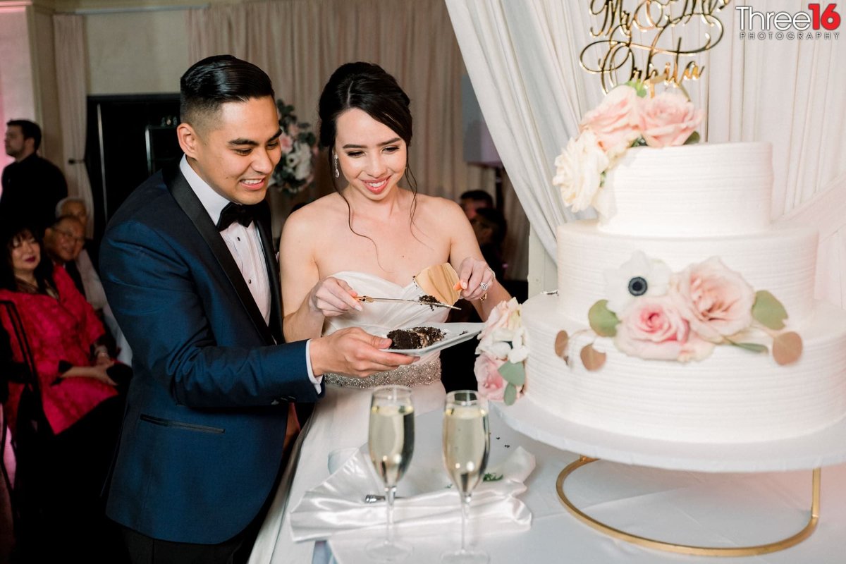 Bride and Groom cut their 3-tiered white wedding cake