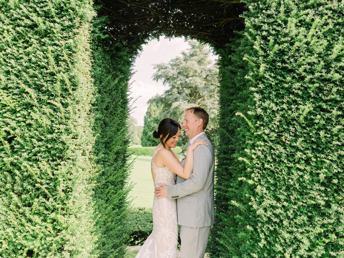 Bride and groom pose in the gardens of Chateau De La Hulpe in Belgium for their destination wedding