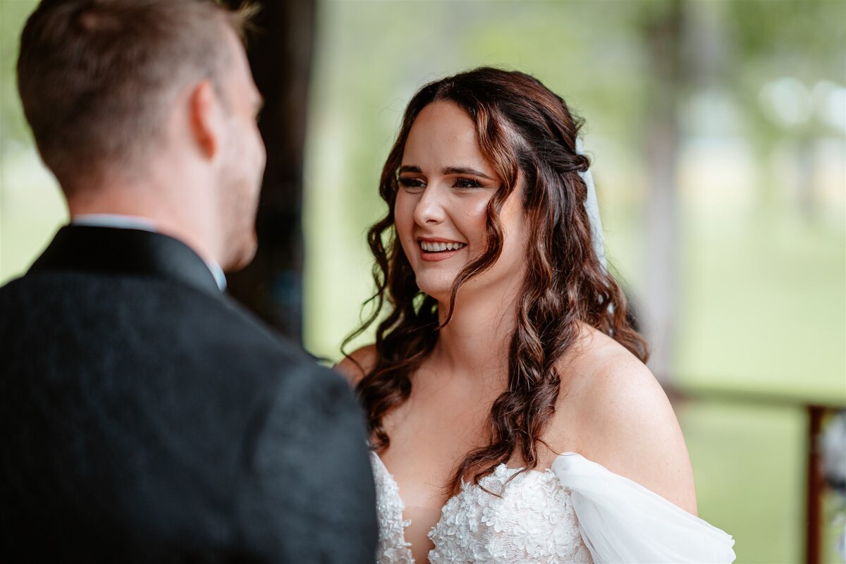 A couple stands lovingly at their ceremony, exchanging vows with heartfelt emotion.