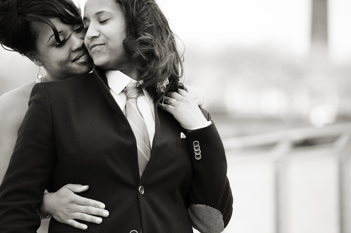 A person leaning back into their partner who is hugging them from behind 
