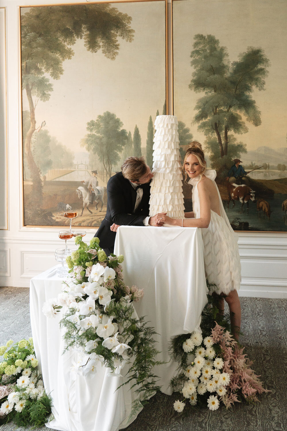 High-end wedding with modern all white wedding cake with ruffles