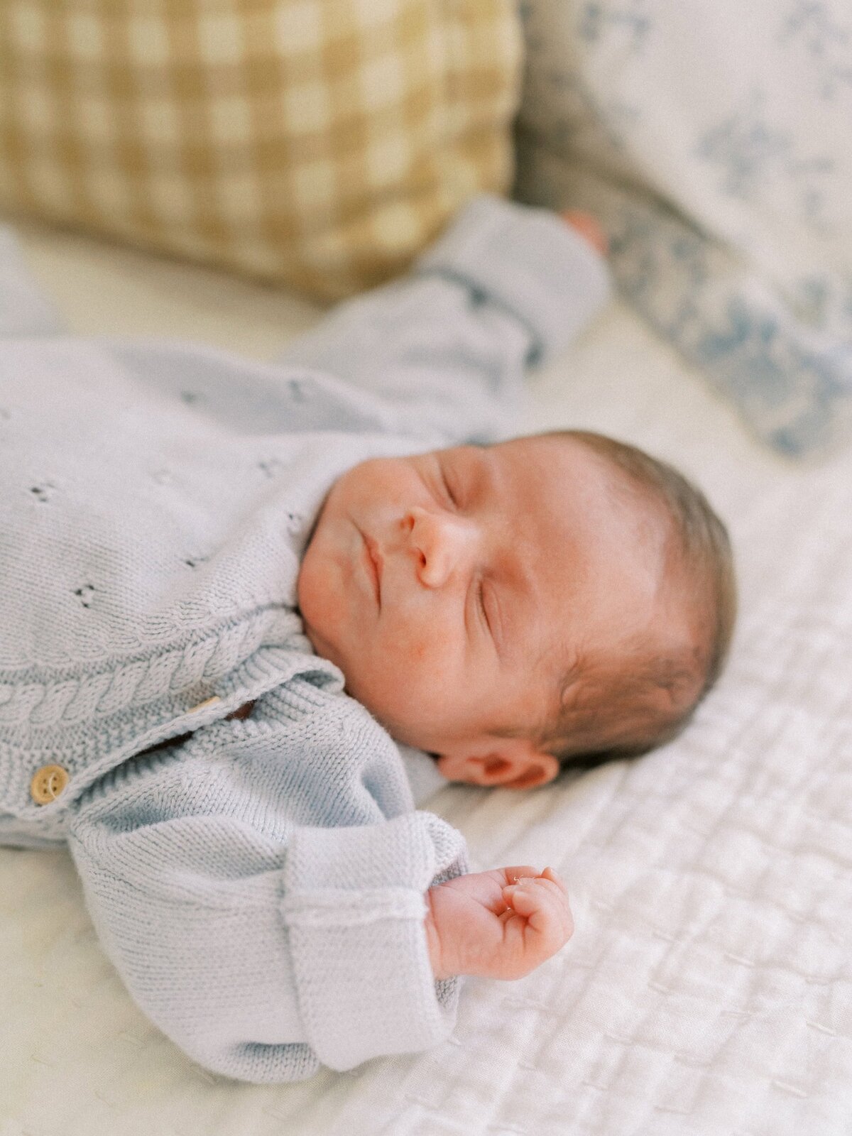 Newborn baby in light blue sweater