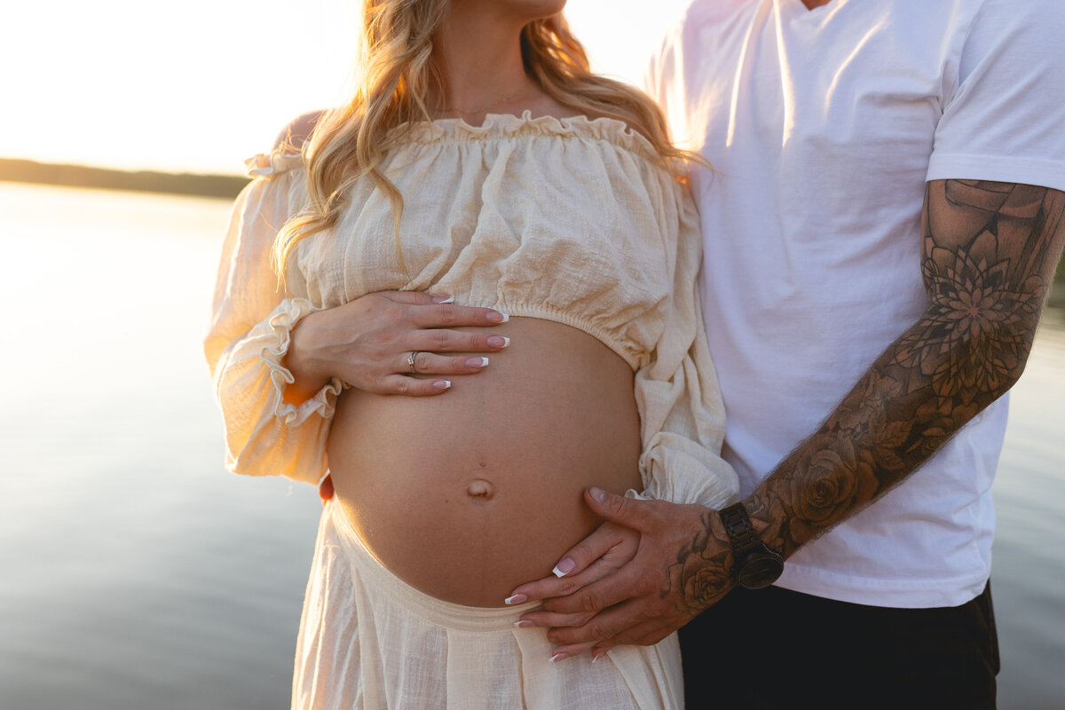 Beach maternity session, mom and dad hug belly