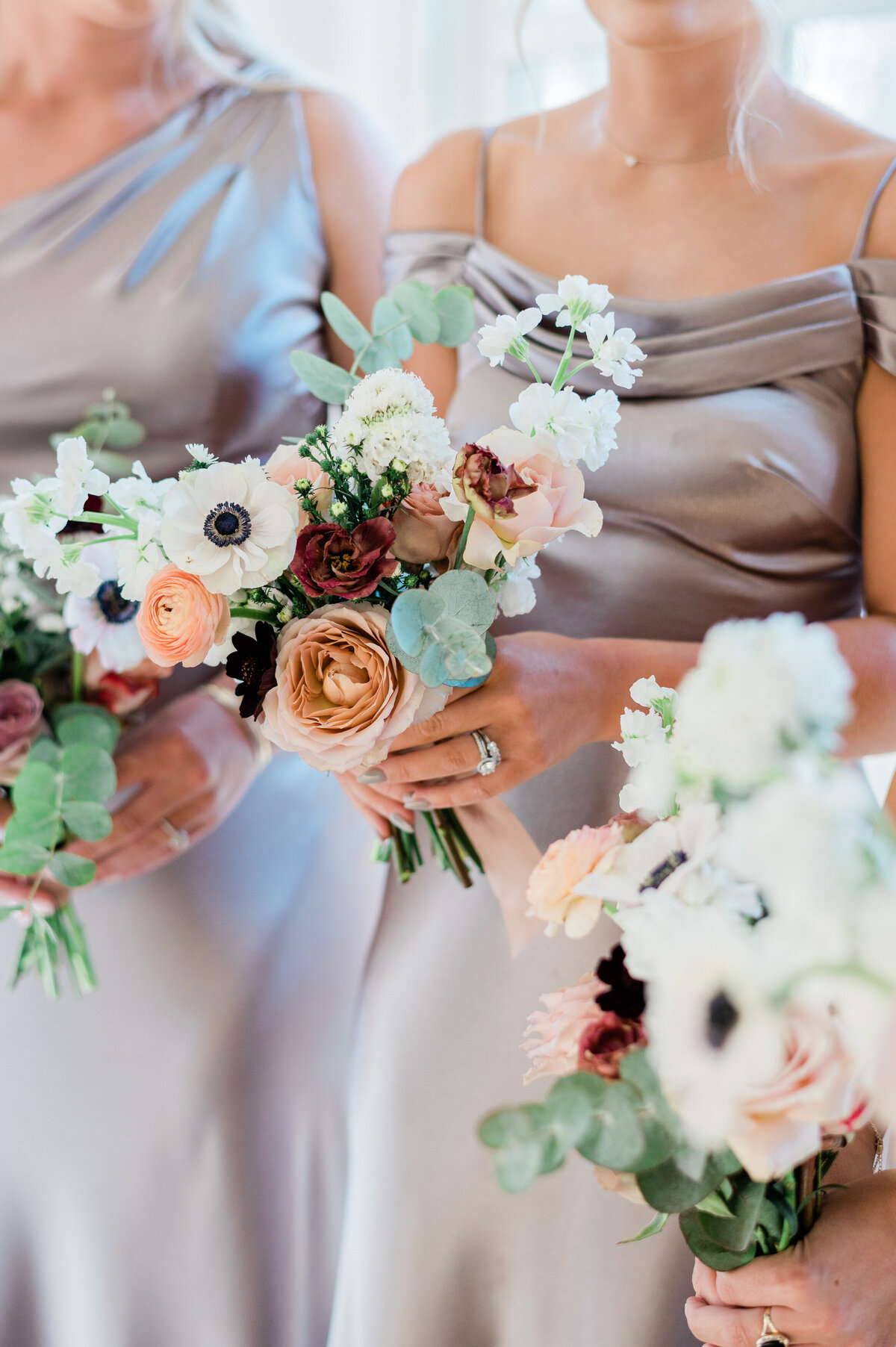 Bridesmaid holds her bouquet with white flowers and dried oranges 