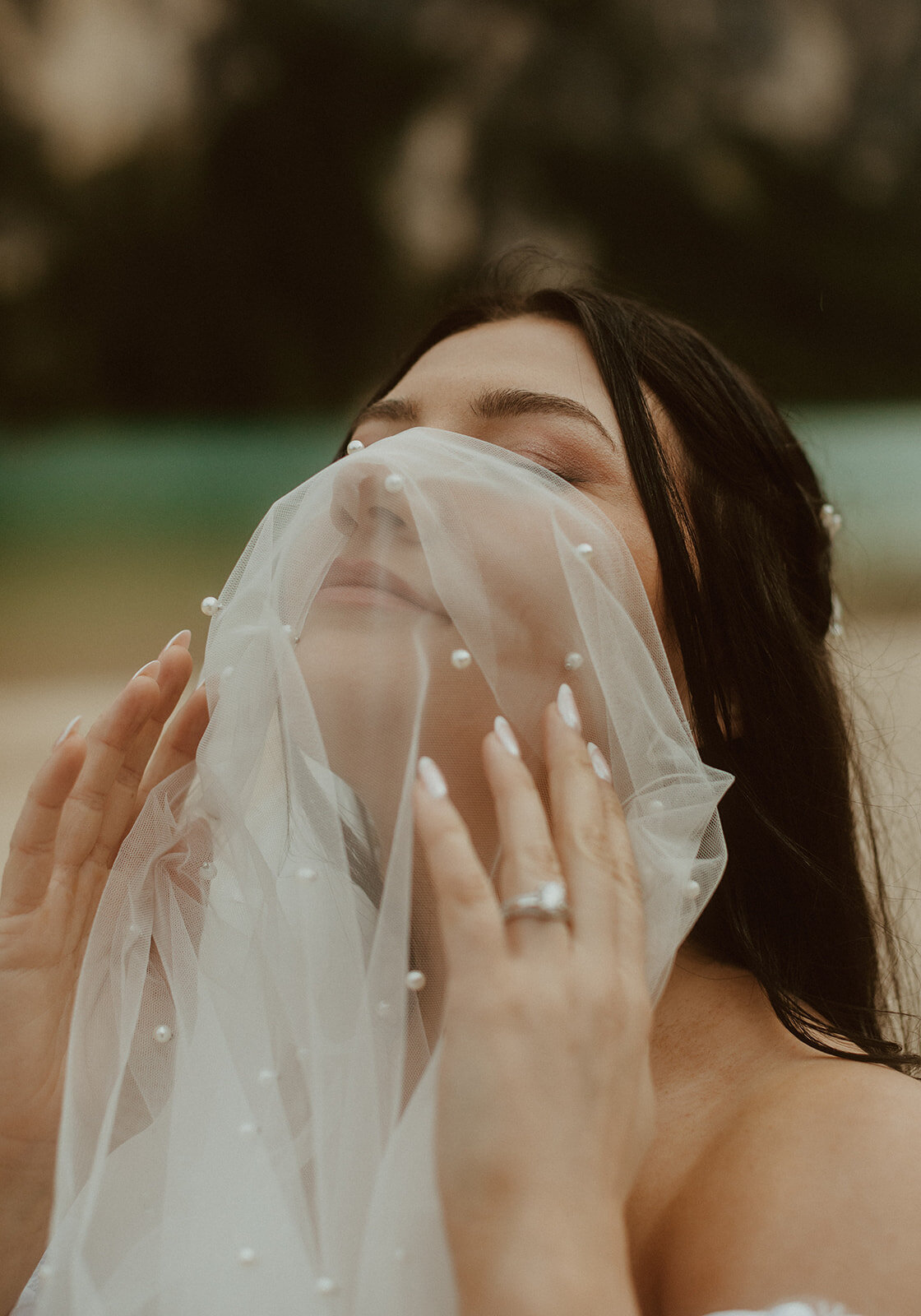 bride with veil over face near lake braies italy