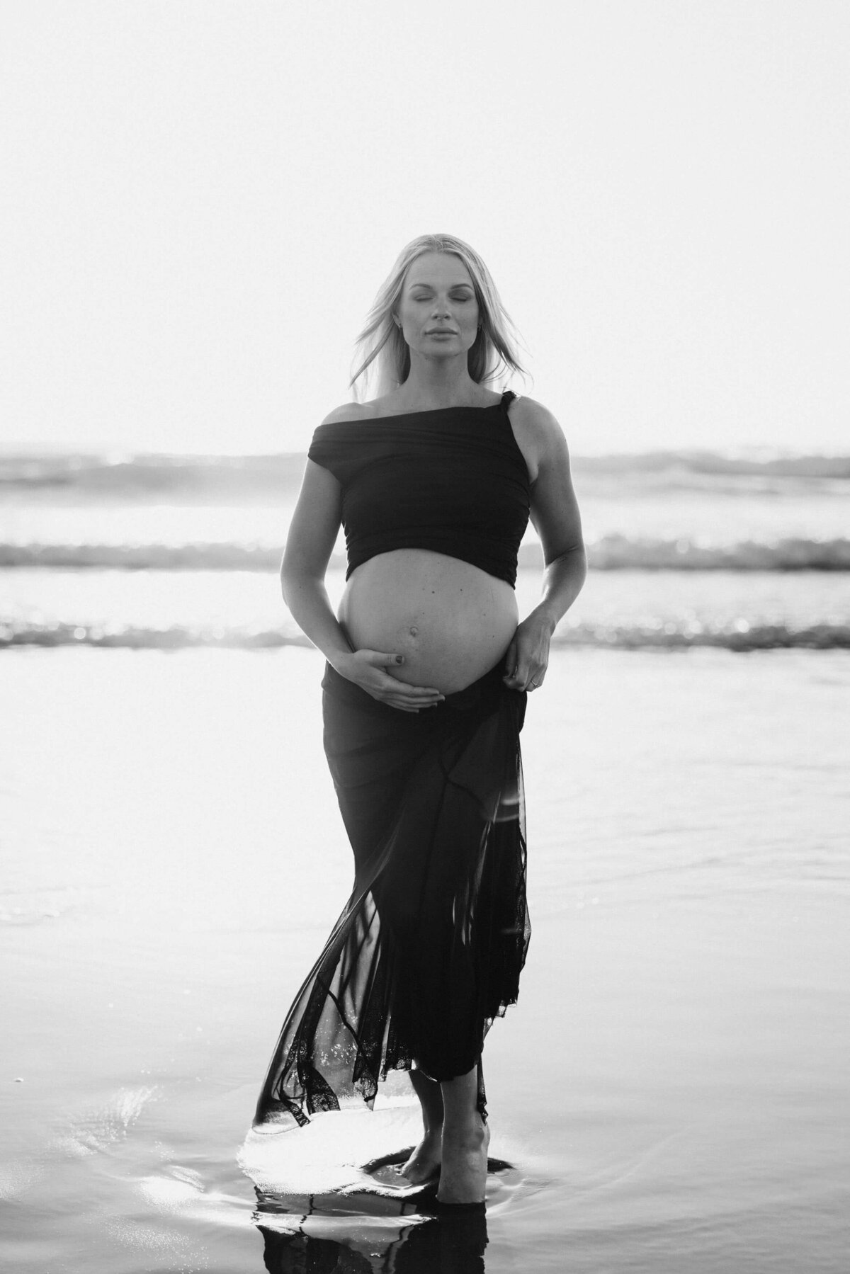 pregnant woman holding her belly in the sea