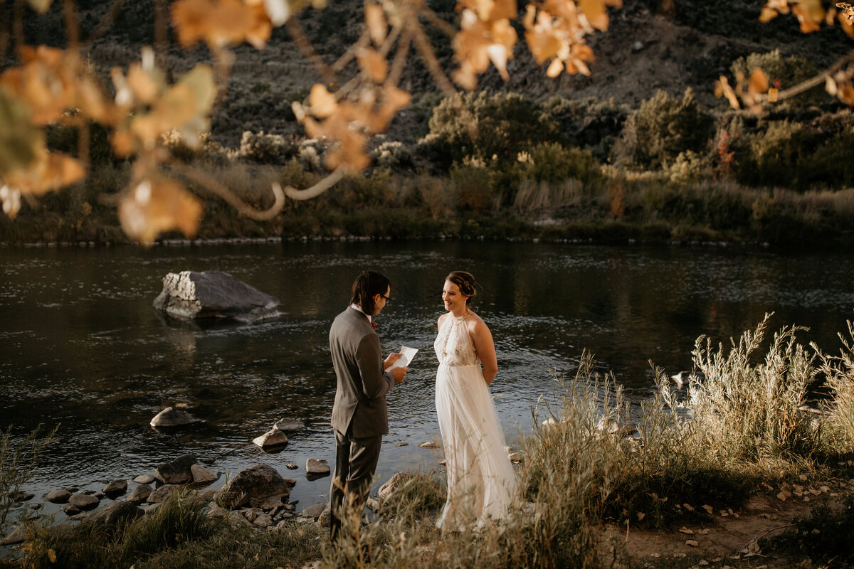 eloping couple exchanging vows by a river