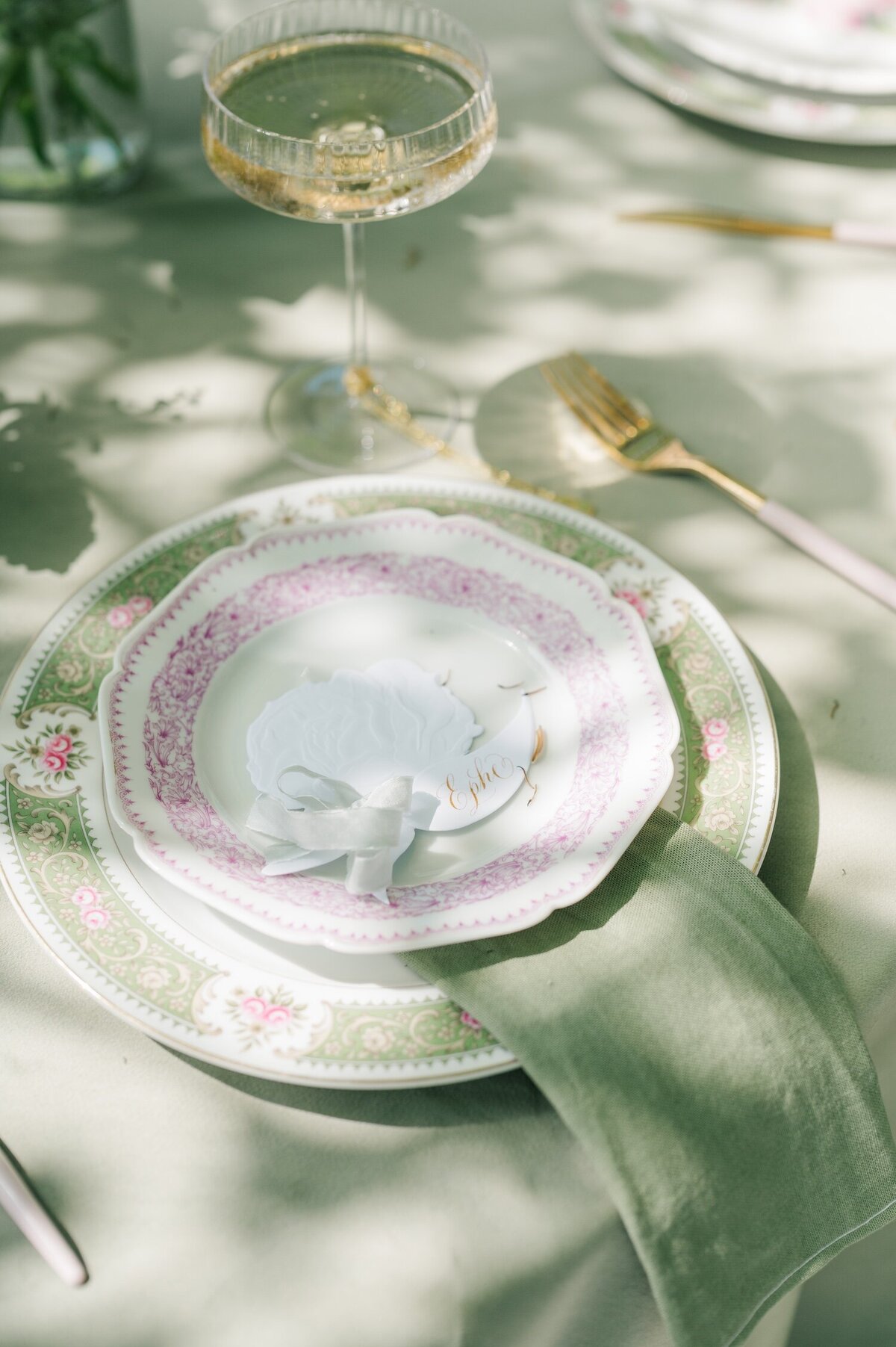 A set of floral plates on top of a green tablecloth at Gwyn Careg Inn. 