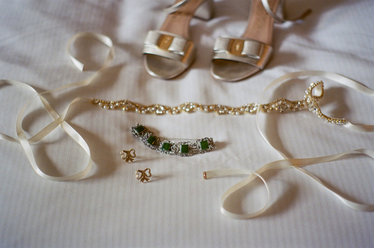 Wedding jewelry laying in front of heels.