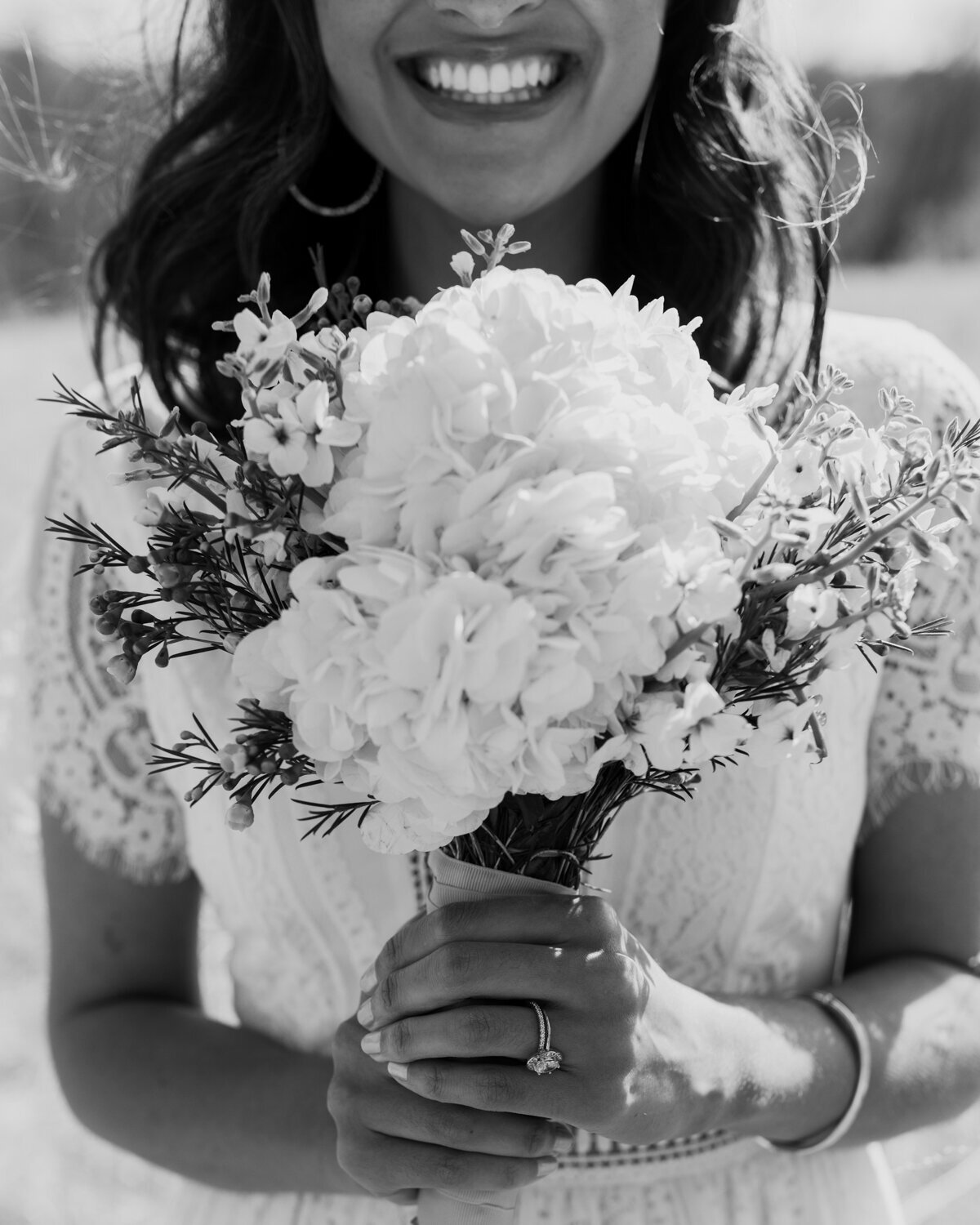 wedding bouquet with bride smiling in the background