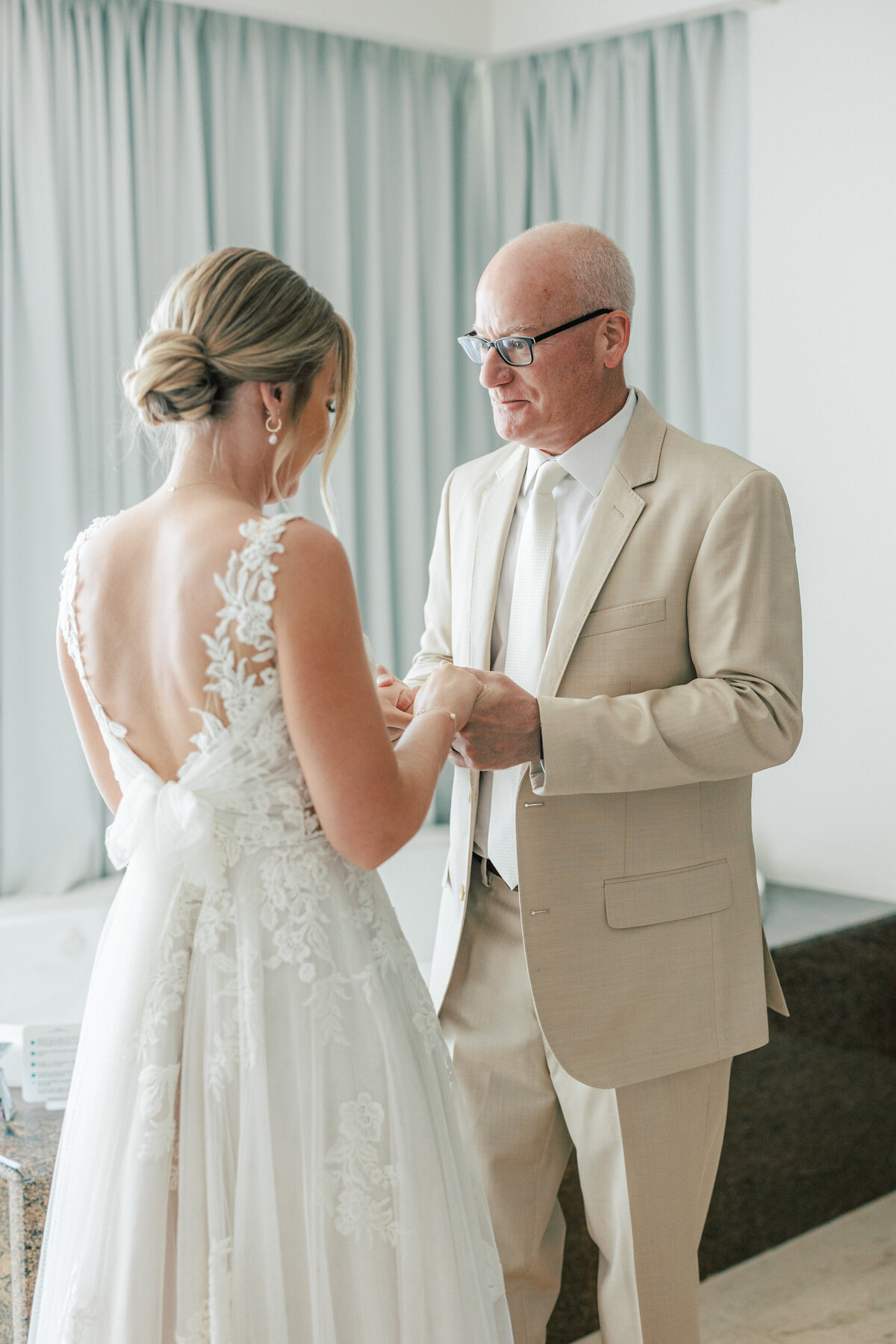 Bride holding hands with her dad in a tender pre-ceremony moment during Cancun wedding, documented beautifully.