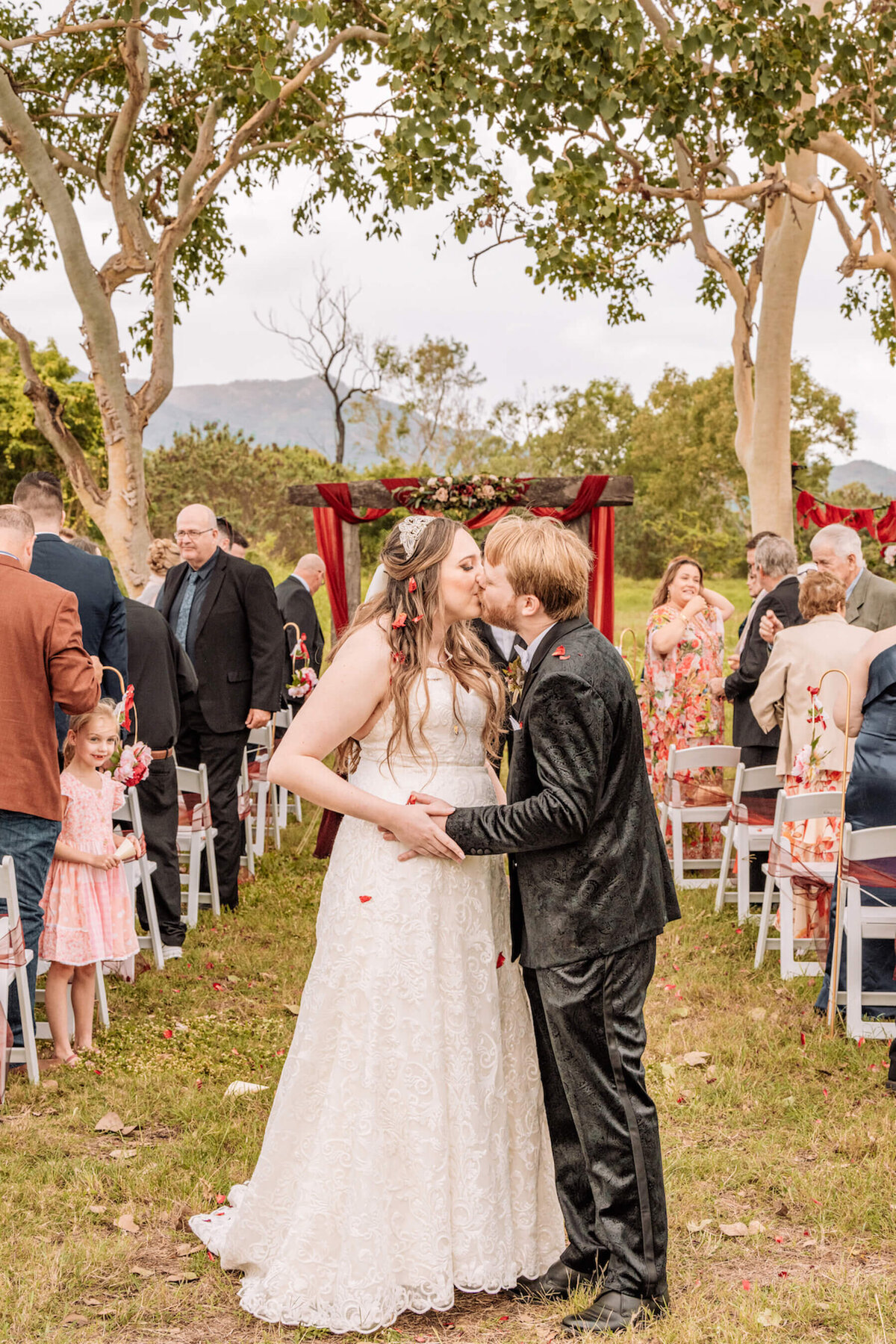A beautiful garden wedding ceremony with floral decorations and guests seated under a clear blue sky. - photo by Jamie Simmons