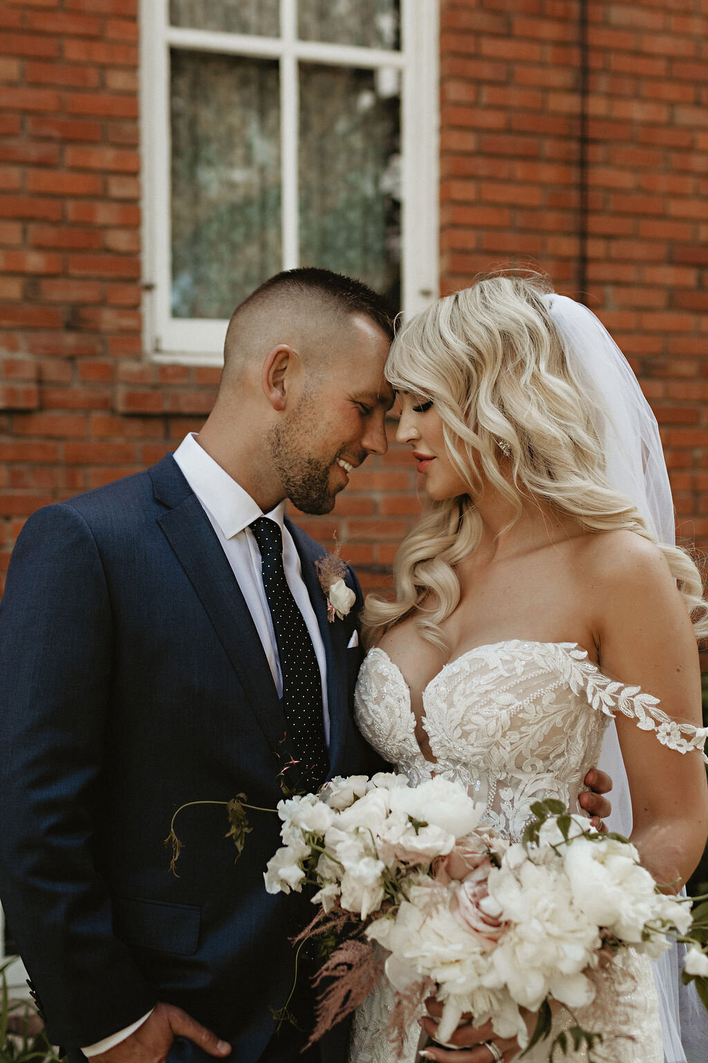 Bride and groom touching foreheads during photo session.